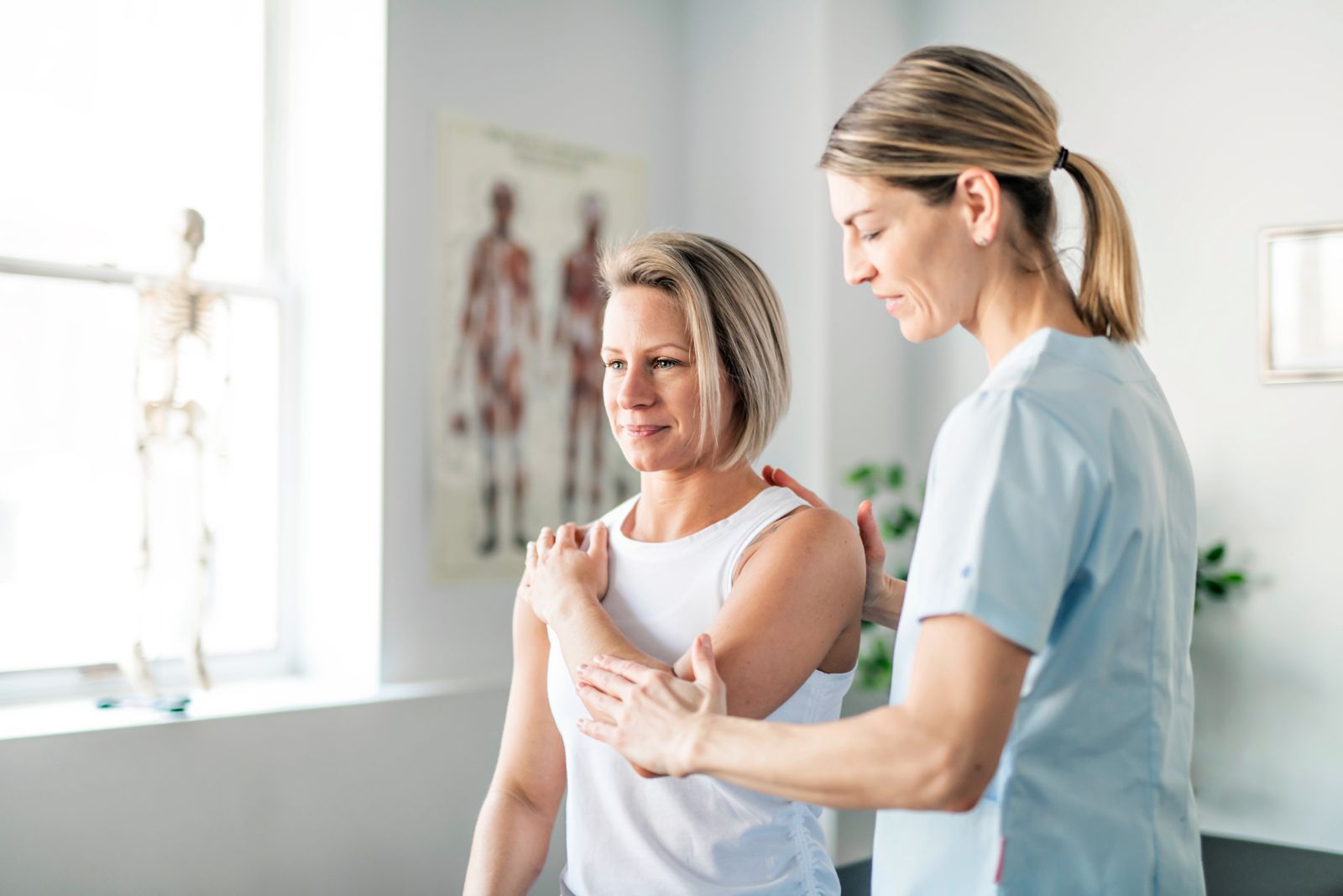 Image of a Physical Therapist adjusting a patient's arm