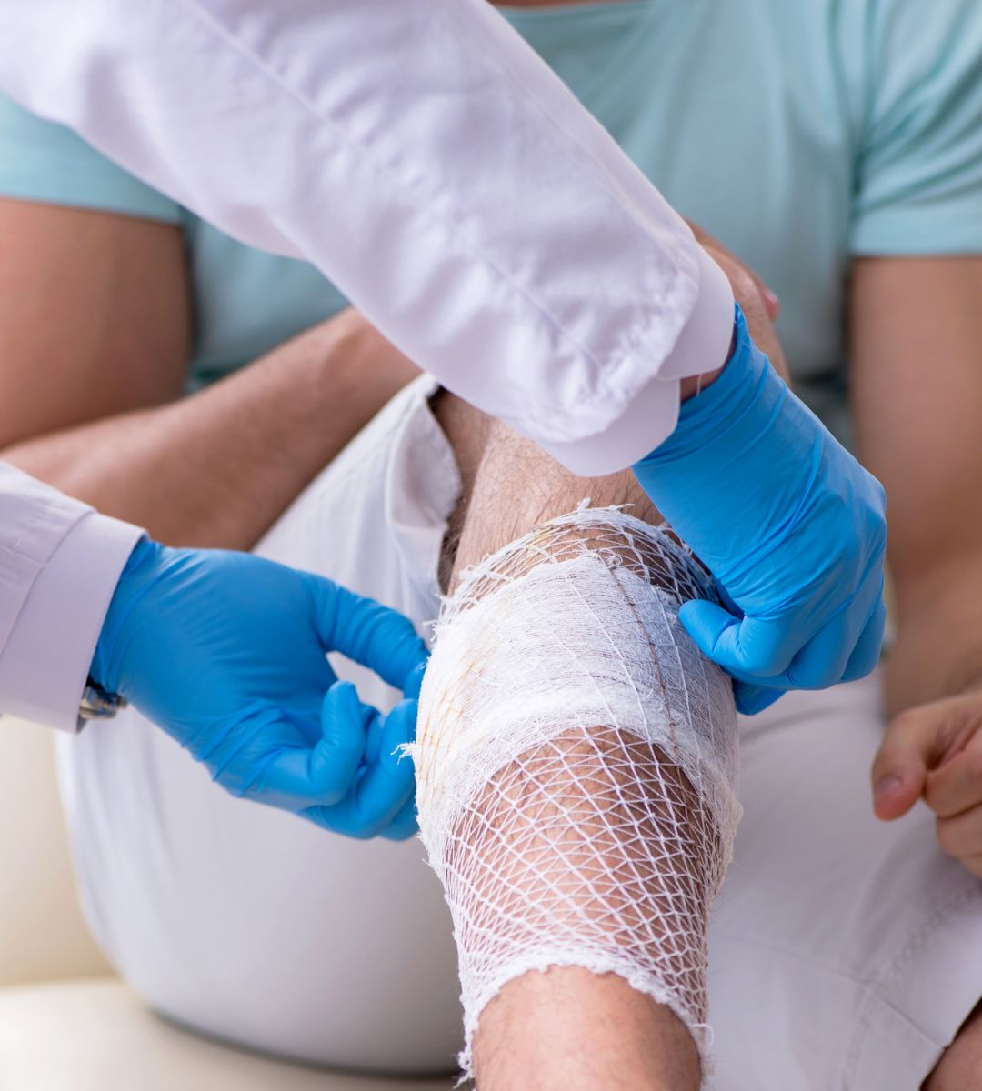 Physician dressing a wound on a patient's leg